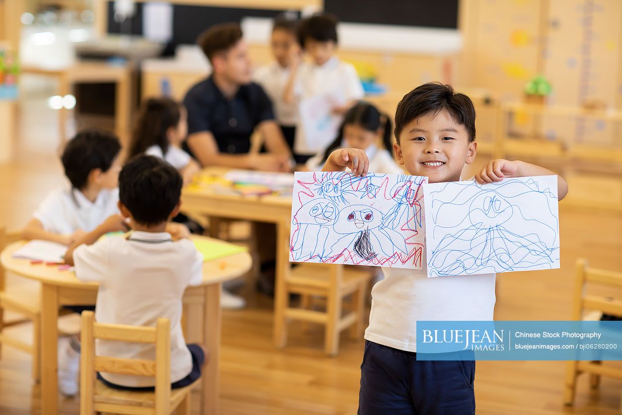 Little Chinese boy showing his painting
