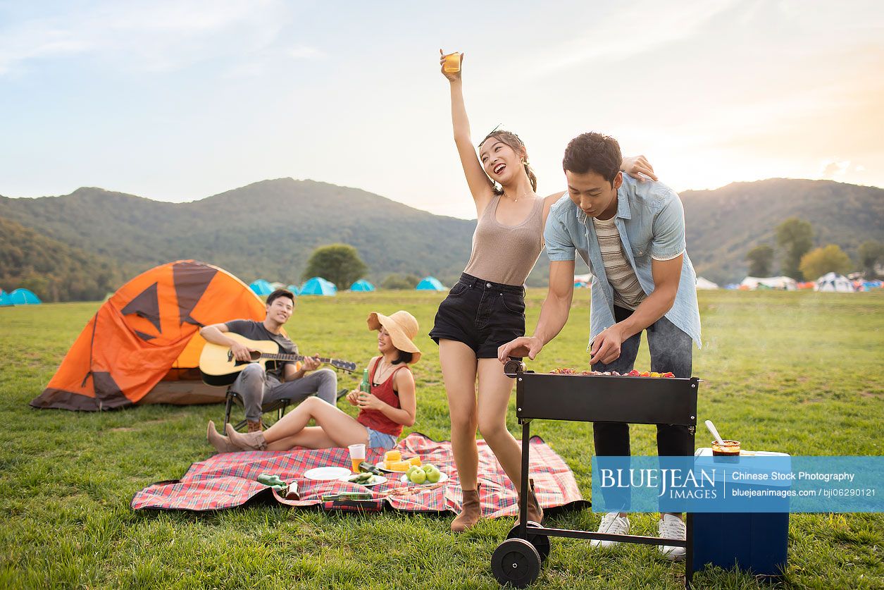 Happy young Chinese friends having a picnic outdoors