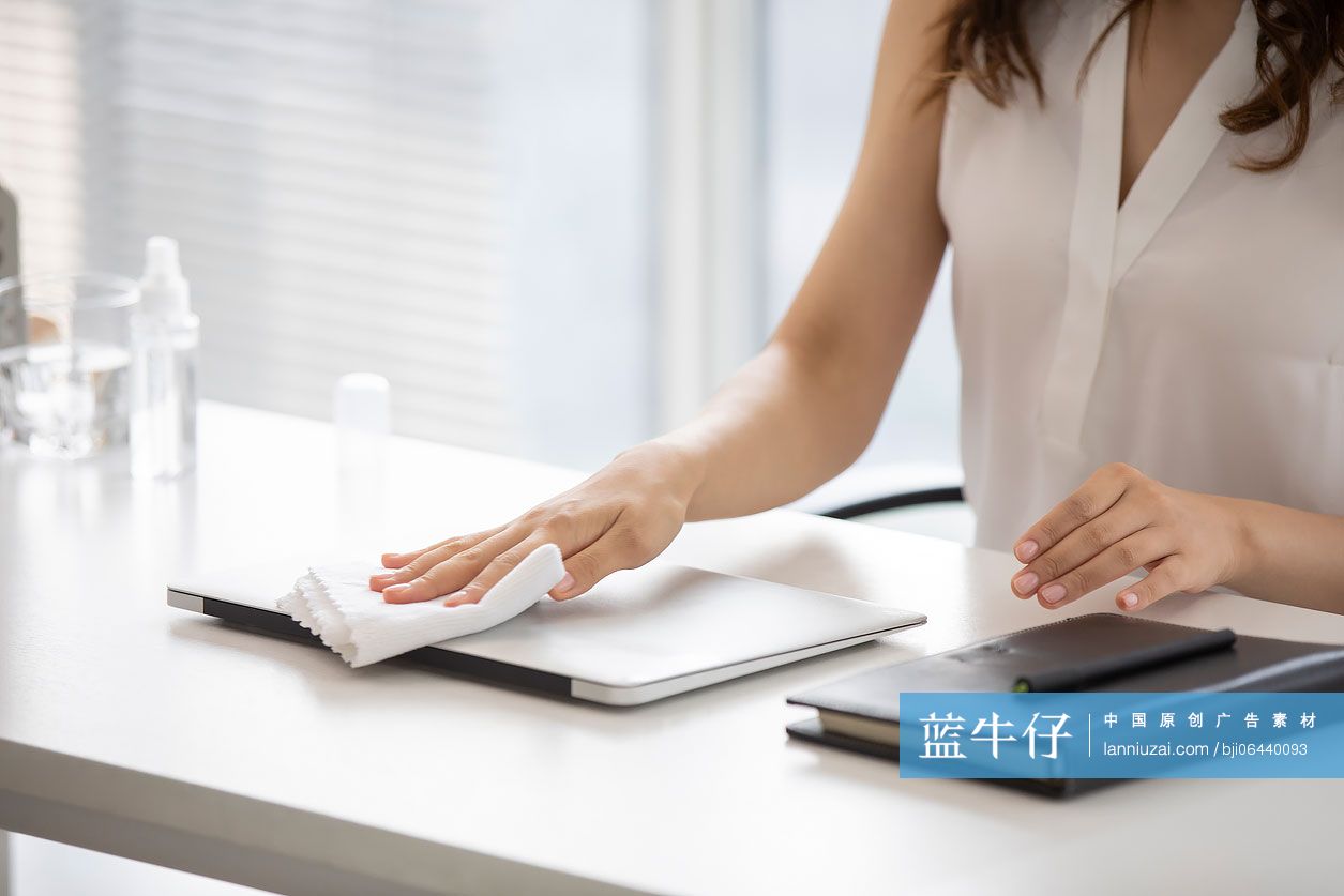 年轻的商务女士在办公室使用消毒液杀菌消毒