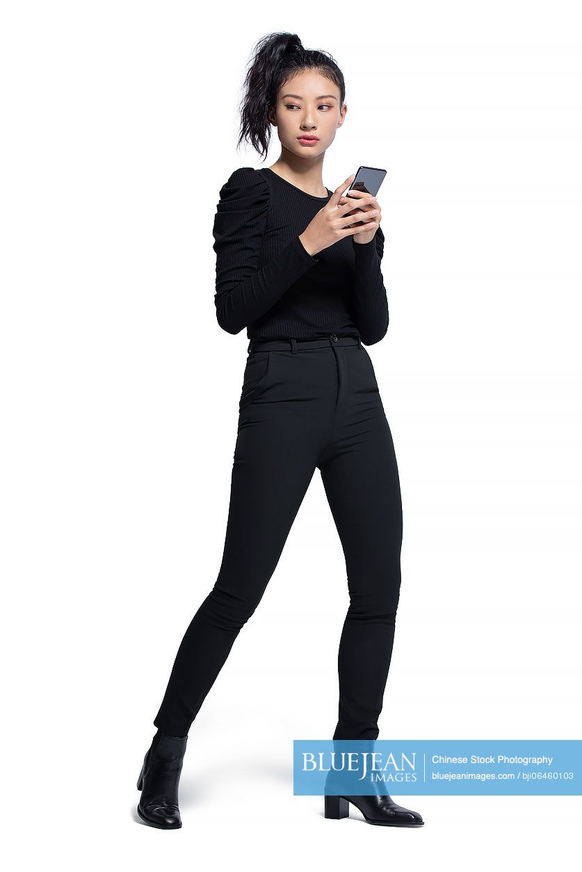 Fashionable young Chinese woman using smart phone