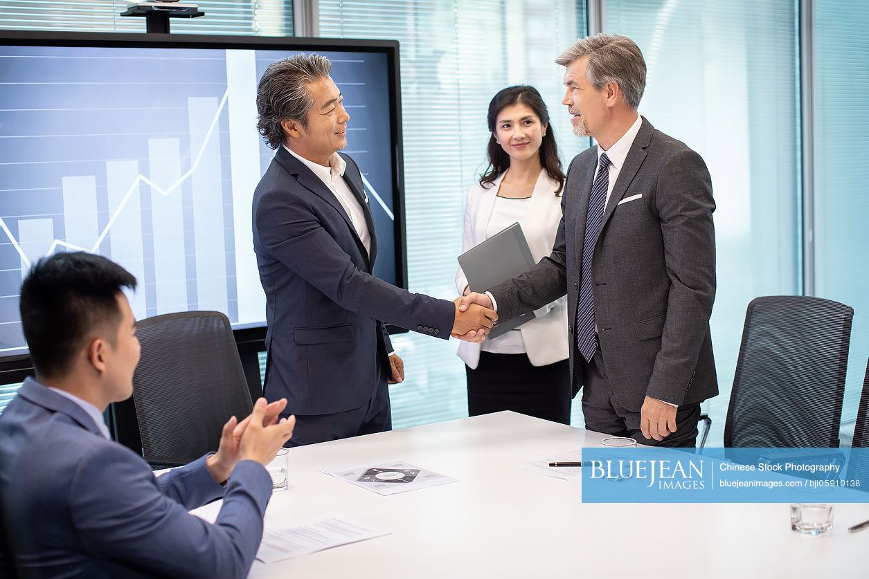 Business people shaking hands in conference room