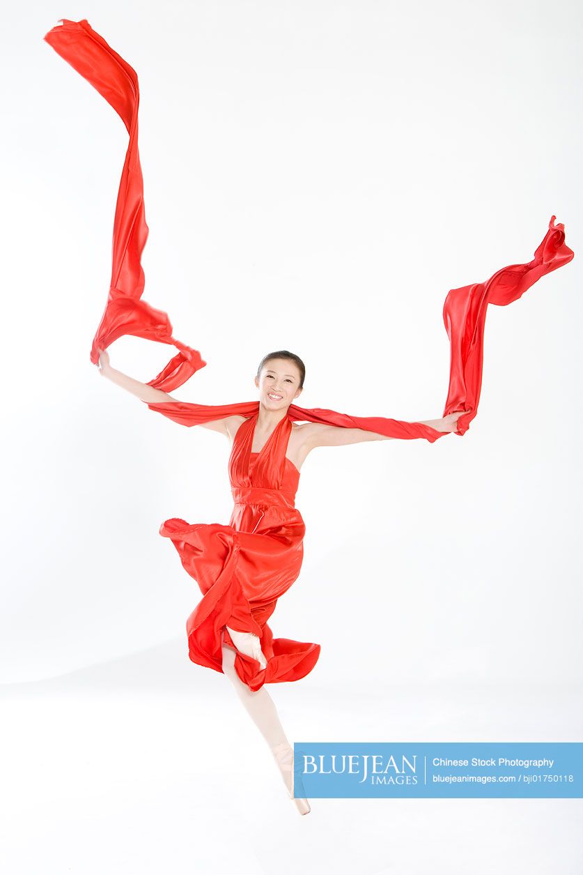 Young Chinese woman in a red dress dancing