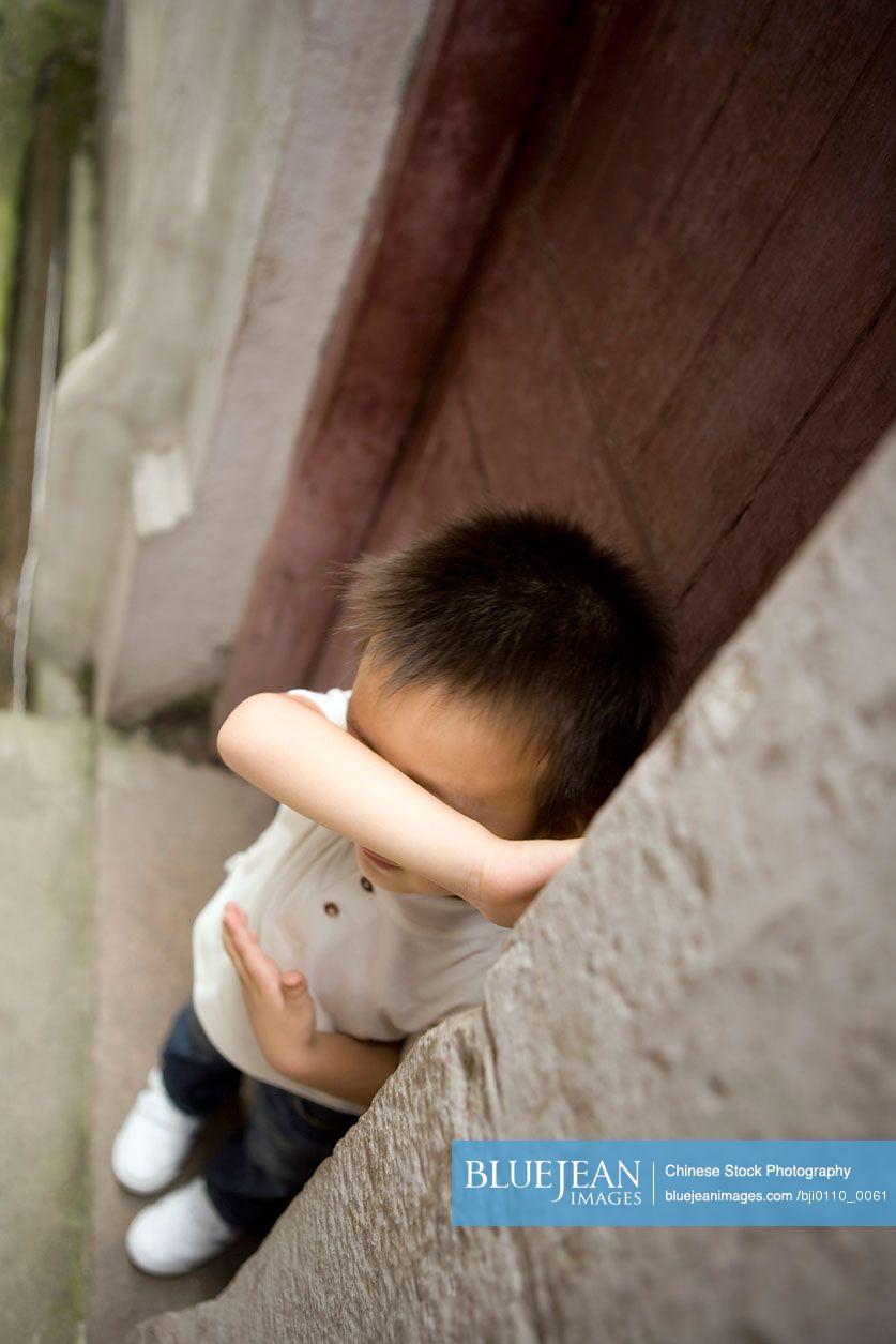 Chinese boy playing hide and seek