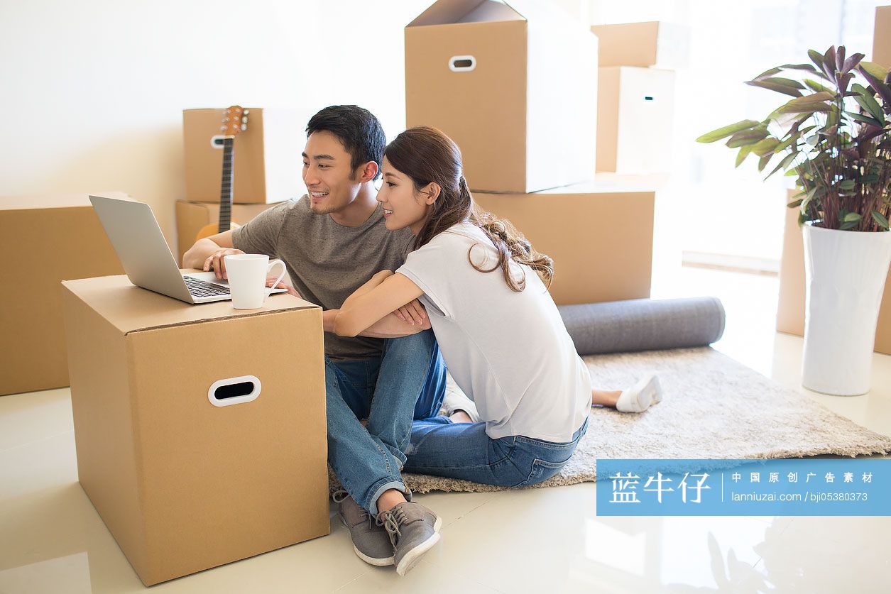 年轻夫妇在新房里使用笔记本电脑-蓝牛仔影像-中国原创广告影像素材