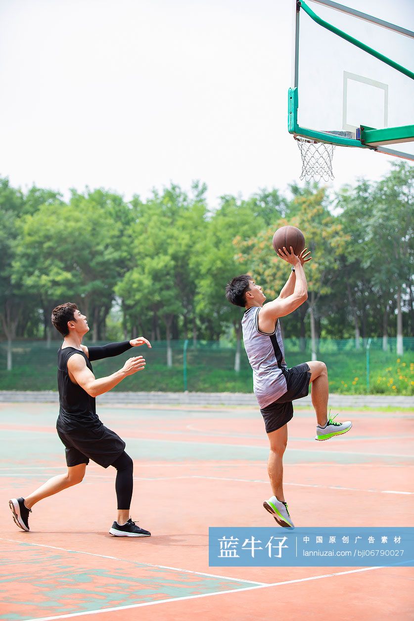 开心的年轻人在篮球场打篮球