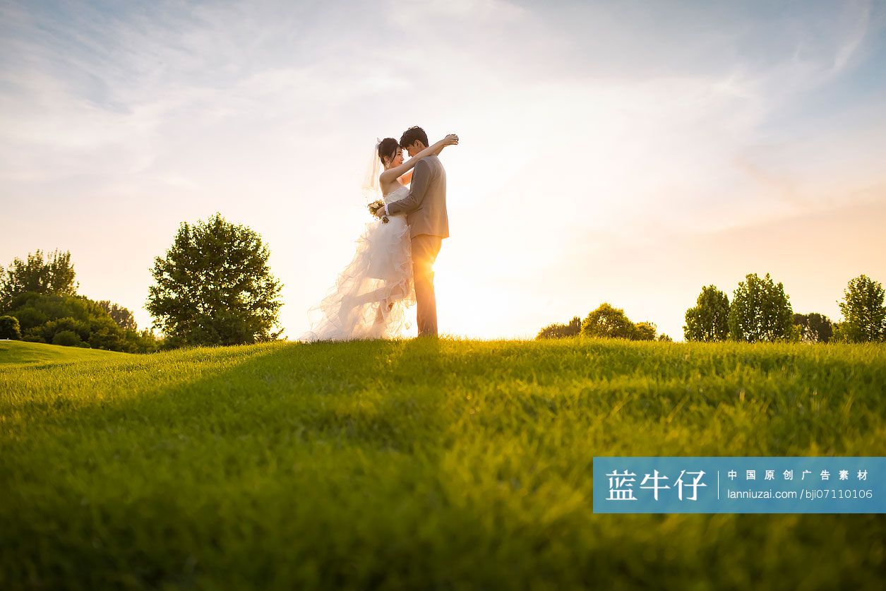 快乐的新郎新娘站在草地上