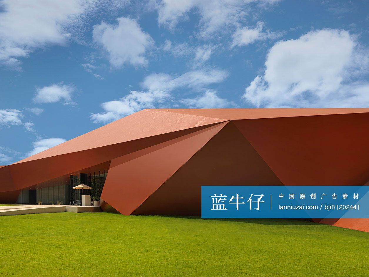 Orange architectural structure against the sky with lawn in foreground