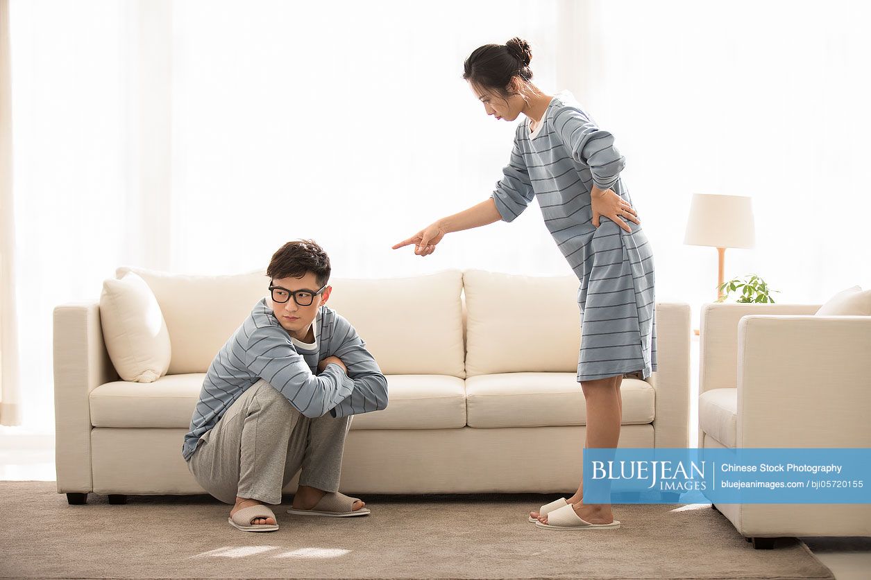 Young Chinese couple arguing in living room