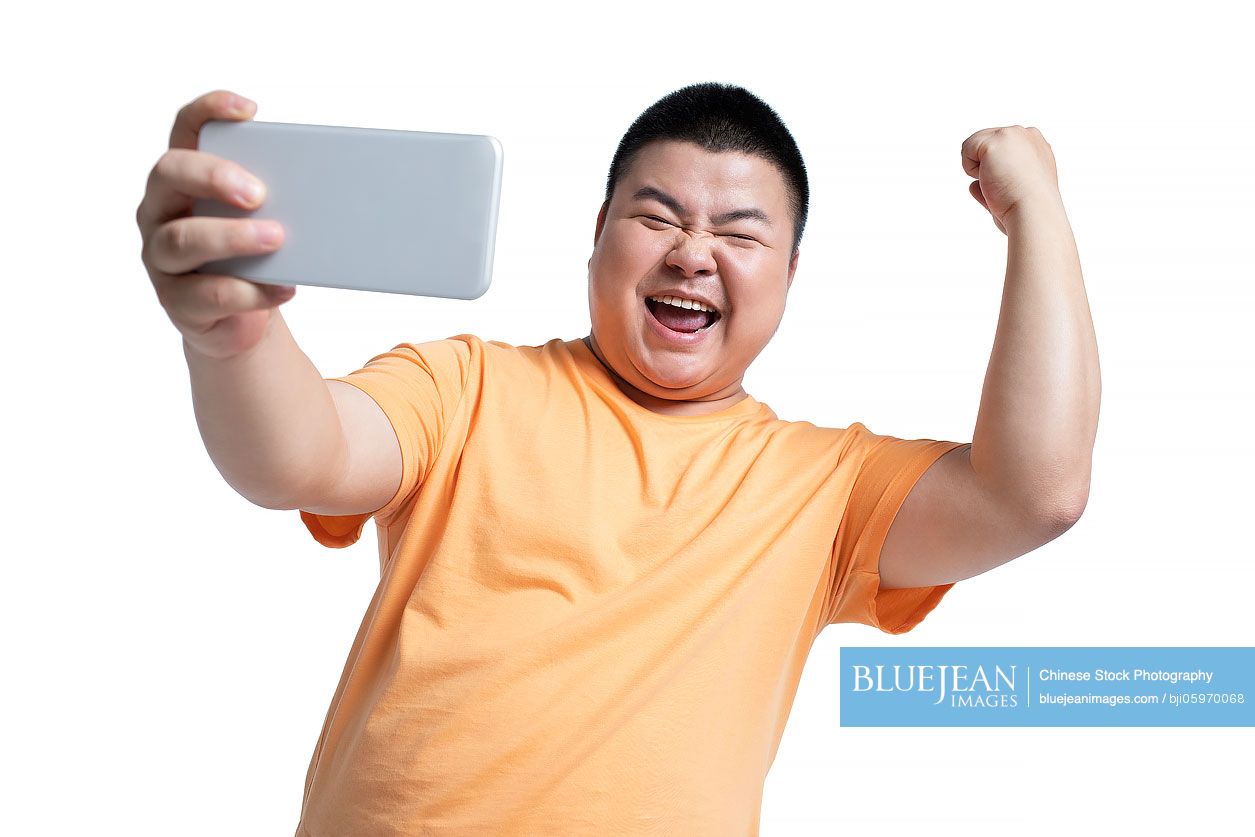 Young Chinese man taking selfie with smartphone-High-res stock photo for  download