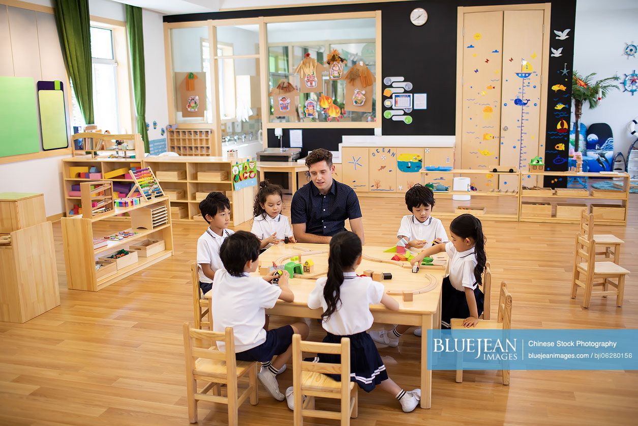 Foreign teacher and children playing in classroom