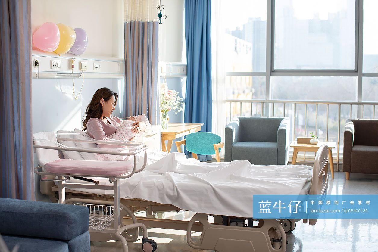 年轻的母亲在病房抱着刚出生的婴儿