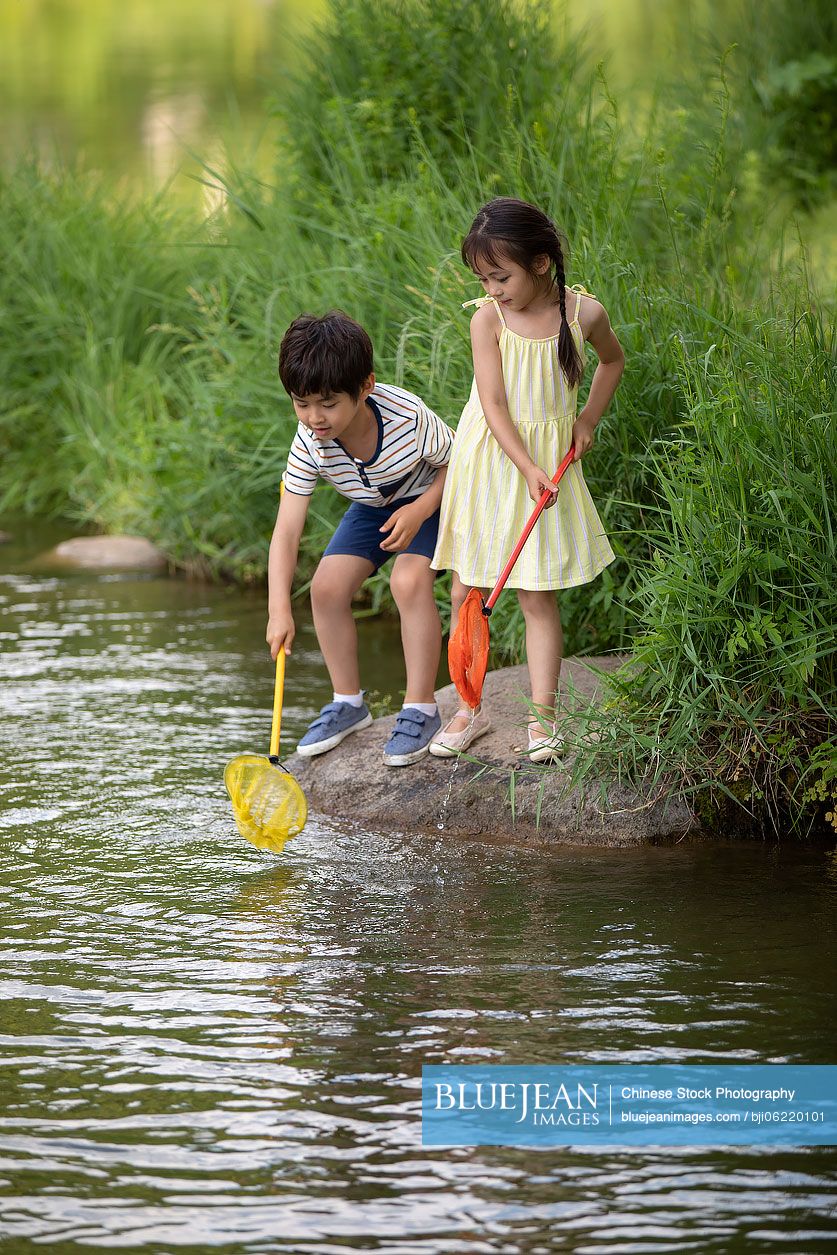 Chinese children playing with fishing net by the river-High-res stock photo  for download