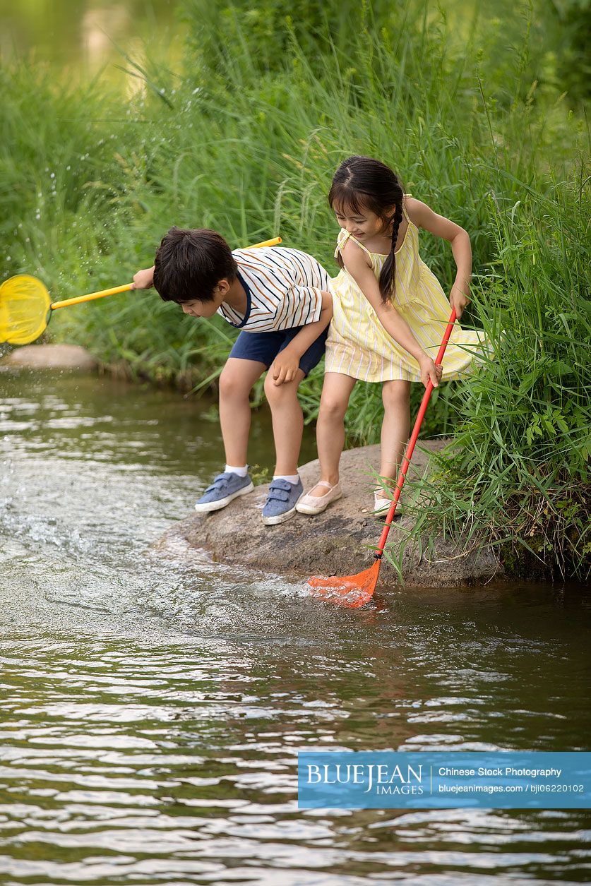 Chinese children playing with fishing net by the river-High-res stock photo  for download