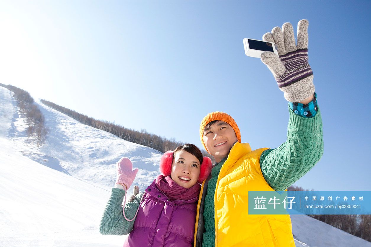 年轻情侣在滑雪场拍照