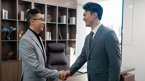 Successful Chinese business people shaking hands in office