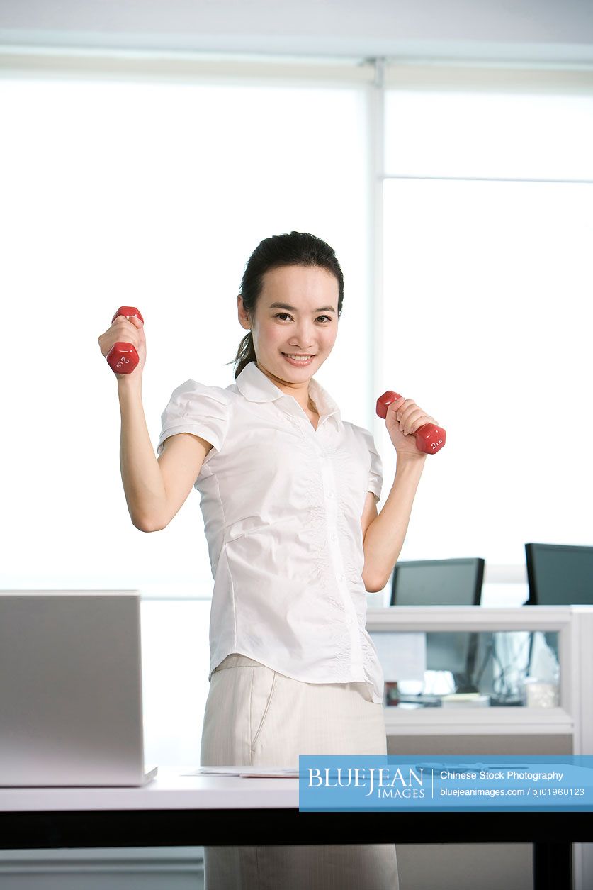 Chinese office worker working out in the office