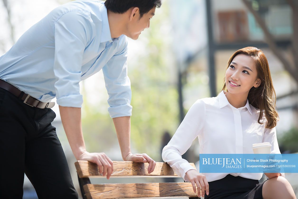 Young Chinese business people chatting outdoors