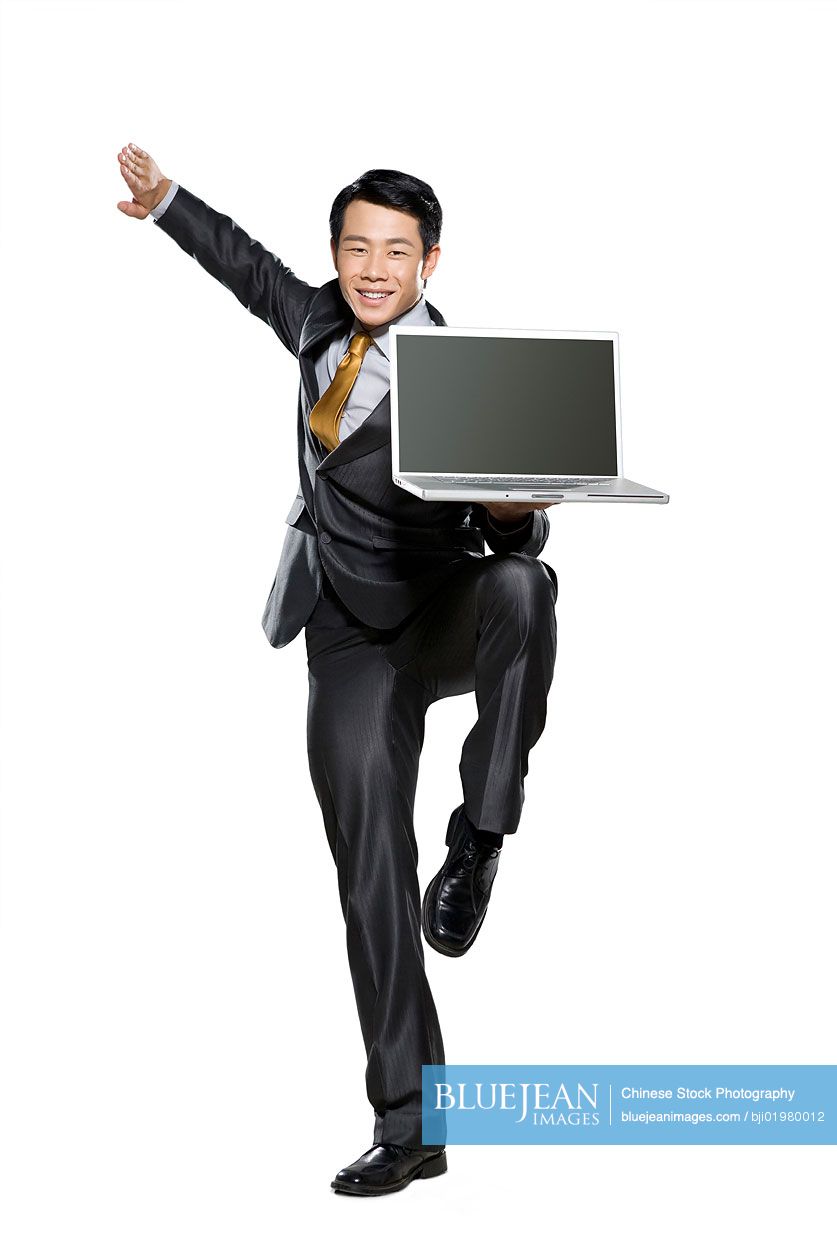 Chinese businessman in fighting stance holding laptop
