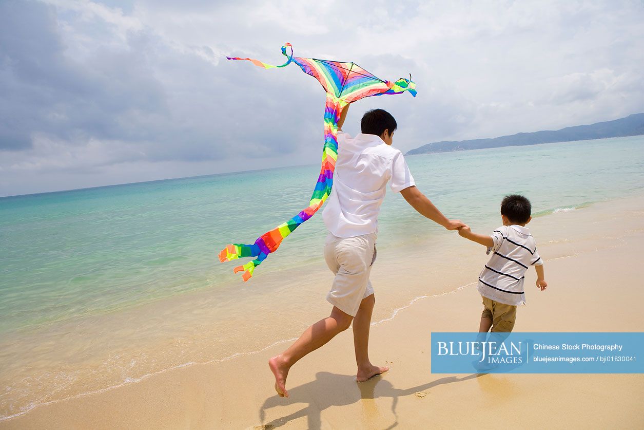 Father and son flying a kite at the beach