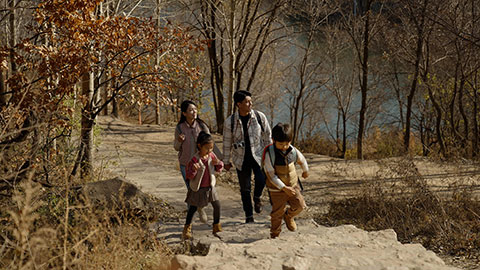 Happy young Chinese family hiking outdoors