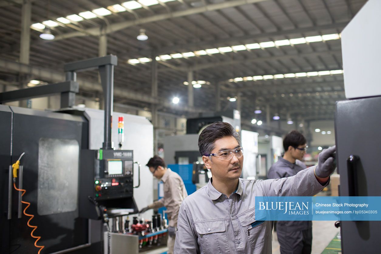 Confident Chinese engineers working in the factory