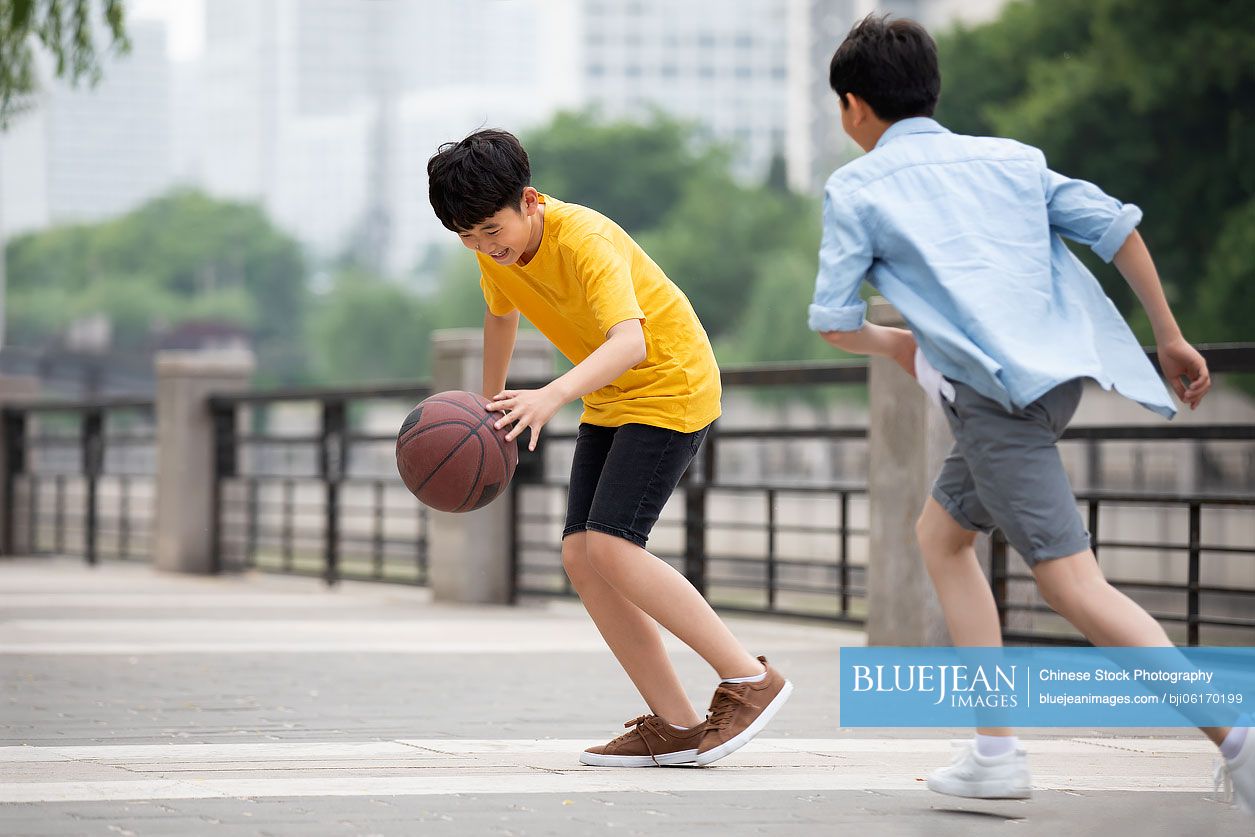 Chinese boys playing basketball outdoors