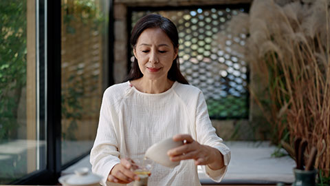 Elegant mature Chinese woman drinking tea in tea room,4K