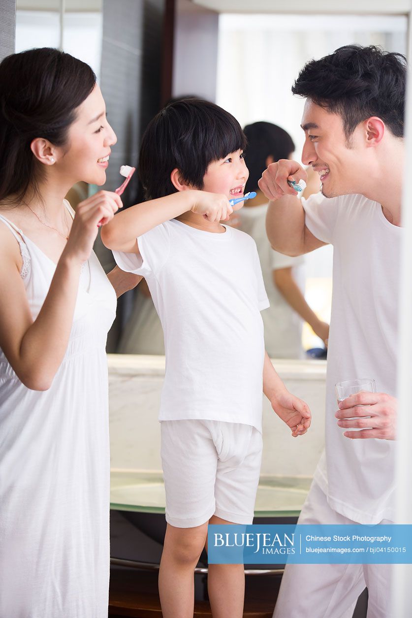 Happy Chinese family brushing teeth