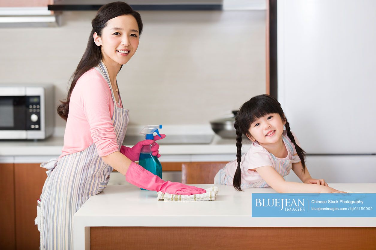 Chinese mother and daughter cleaning kitchen counter