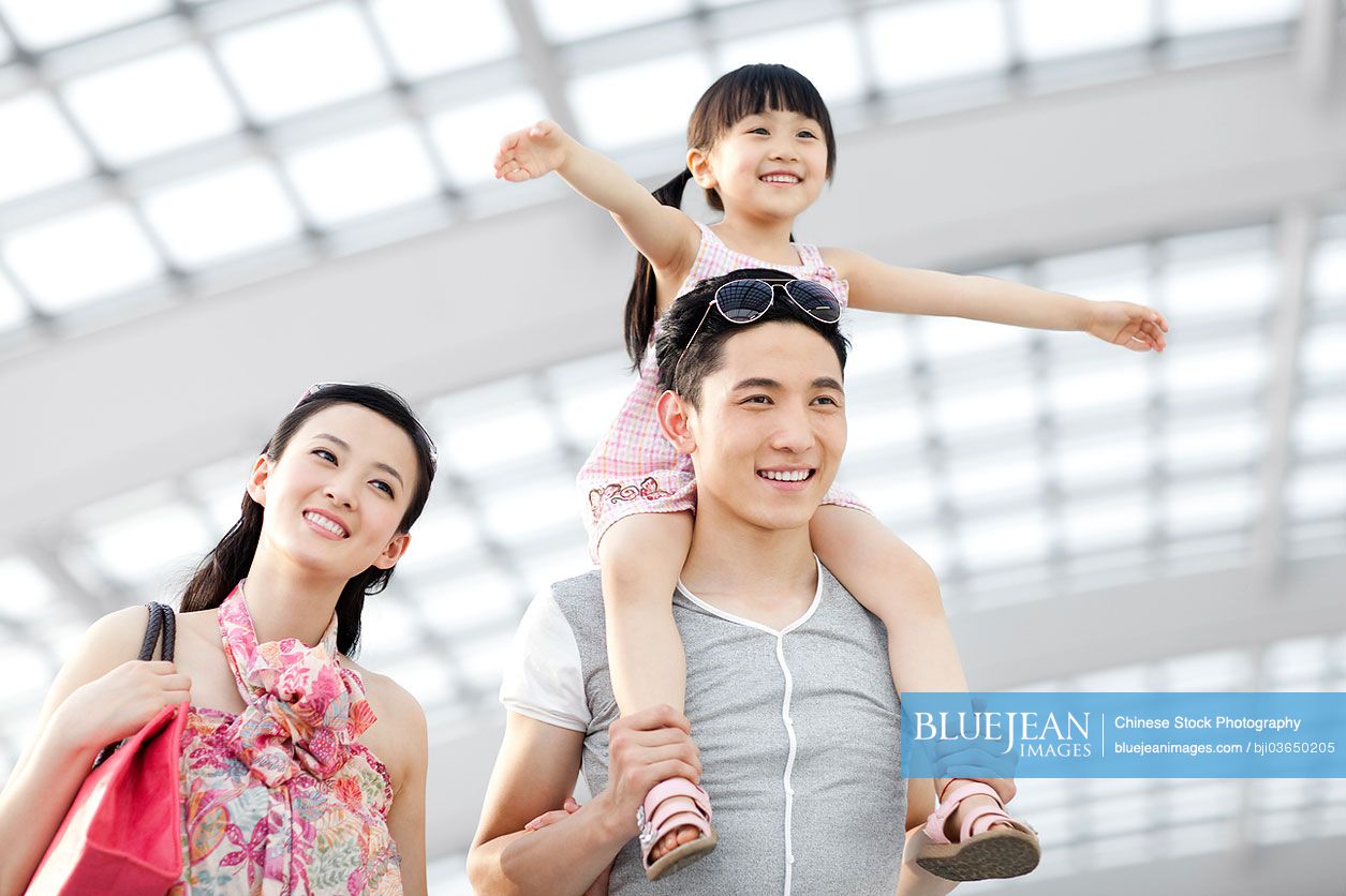 Cheerful young Chinese family at the airport