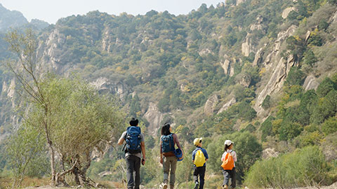 Happy young Chinese family hiking outdoors