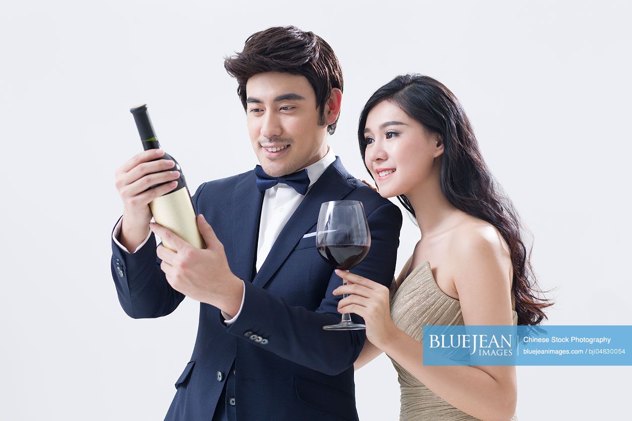 Elegant young Chinese couple enjoying red wine