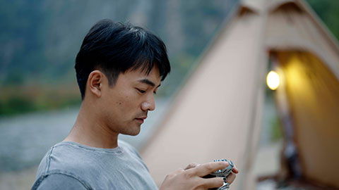 Young Chinese man taking photos outdoors