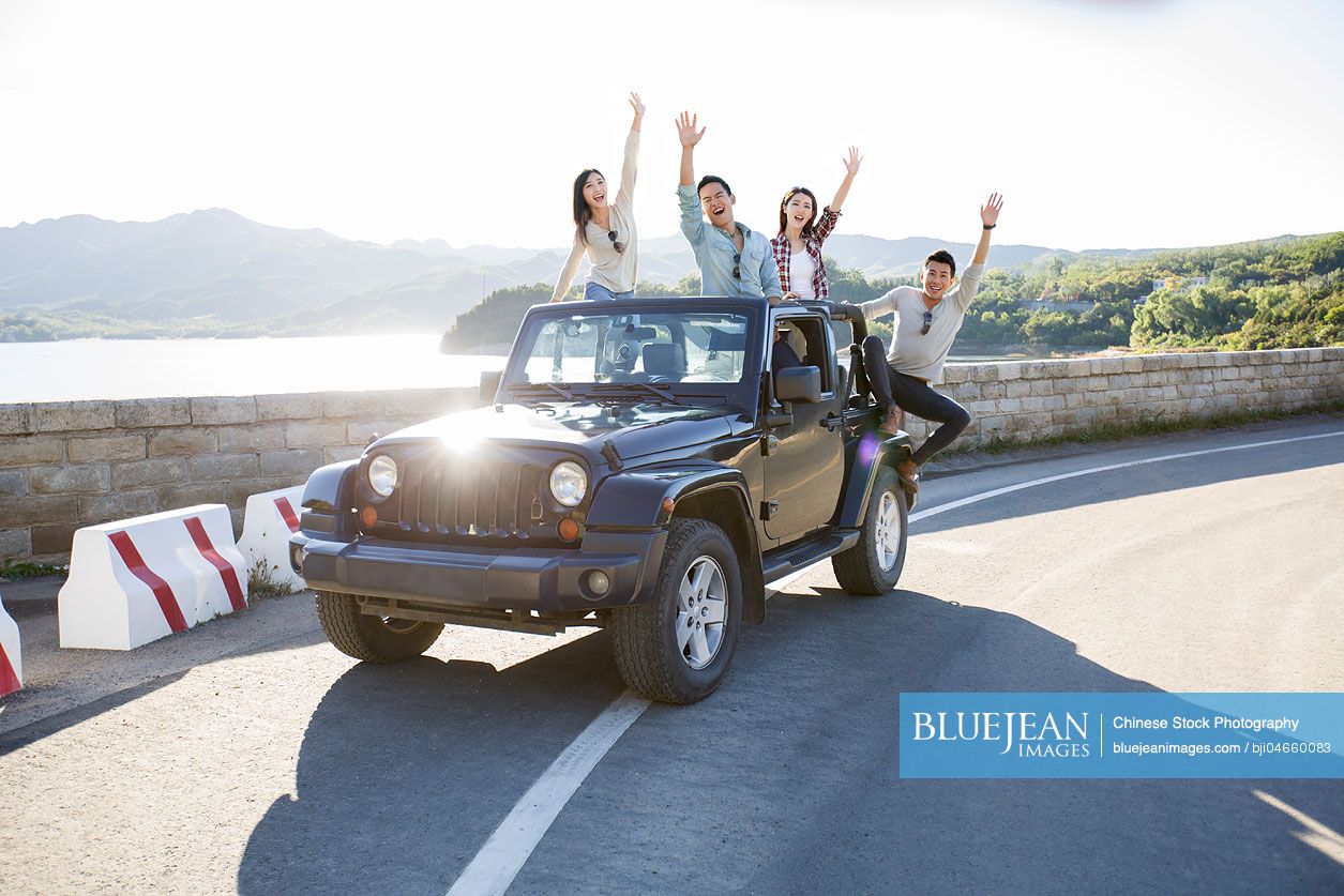 Chinese friends having fun in a jeep in suburbs