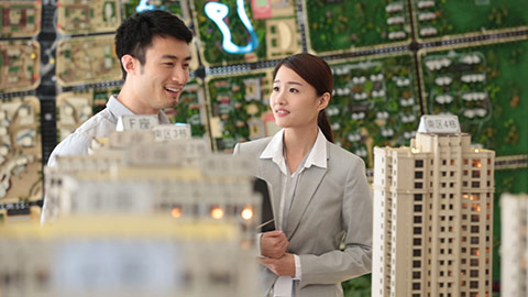 Young Chinese realtor showing architectural model to customer,HD