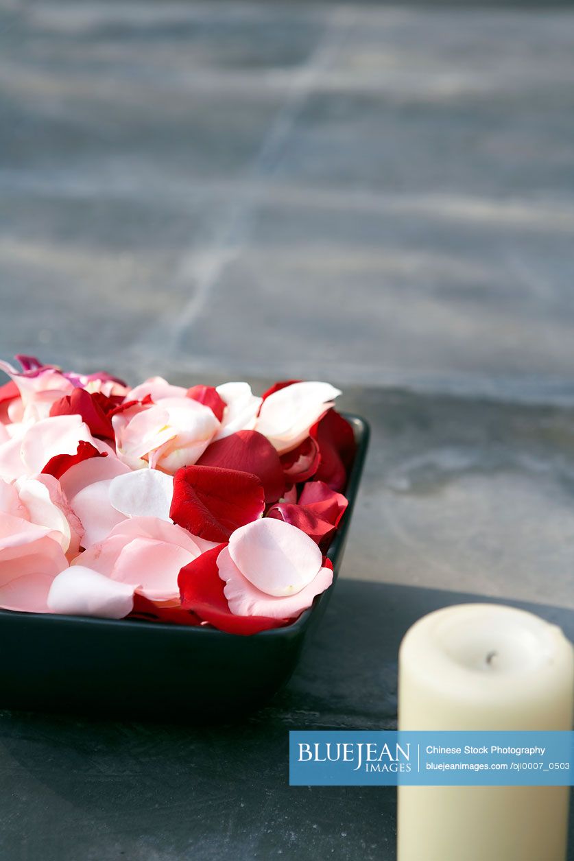Flower Petals And Candle In Front Of A Pond