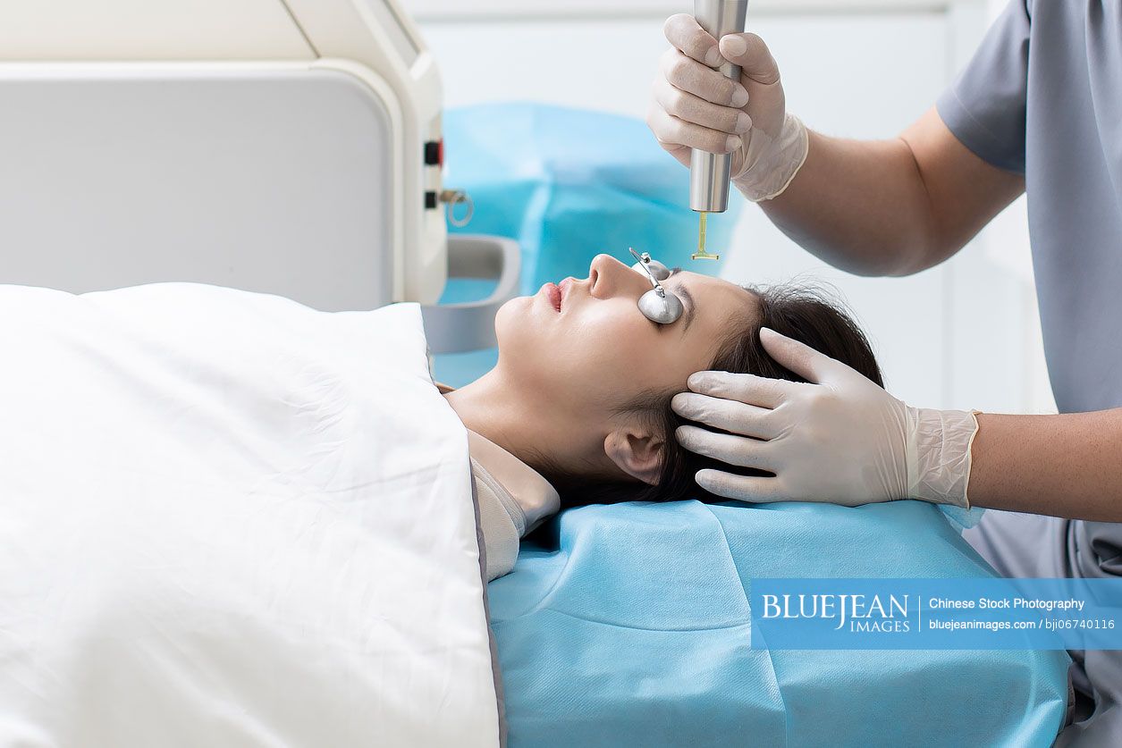 Young Chinese woman receiving face treatment in hospital