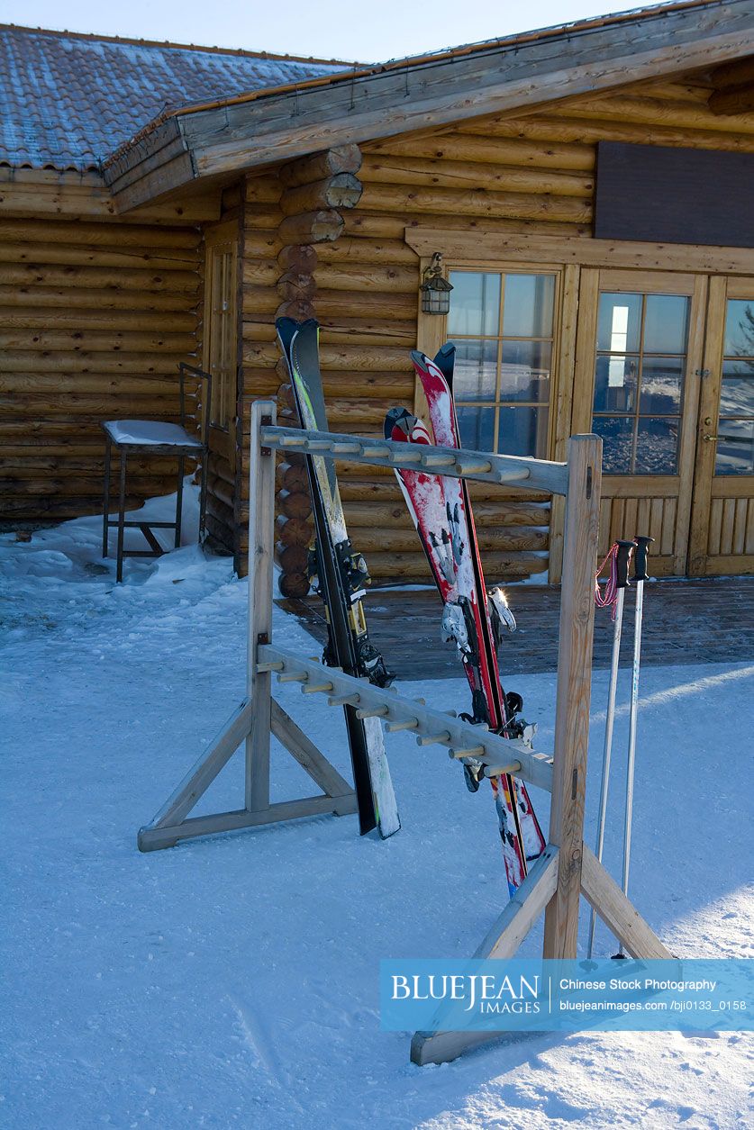 Ski equipment outside a log cabin