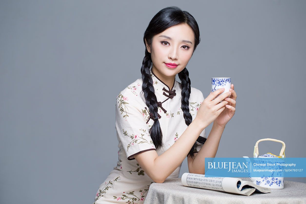 young-beautiful-chinese-woman-in-traditional-cheongsam-drinking-tea