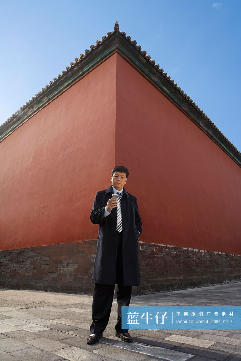 商务男士在宫墙下