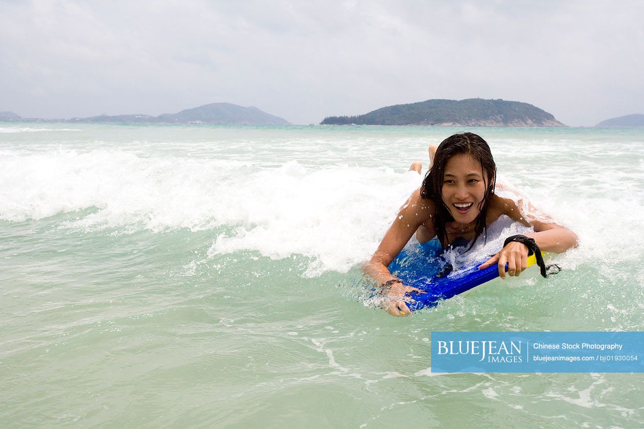 Young Chinese woman wakeboarding in the sea
