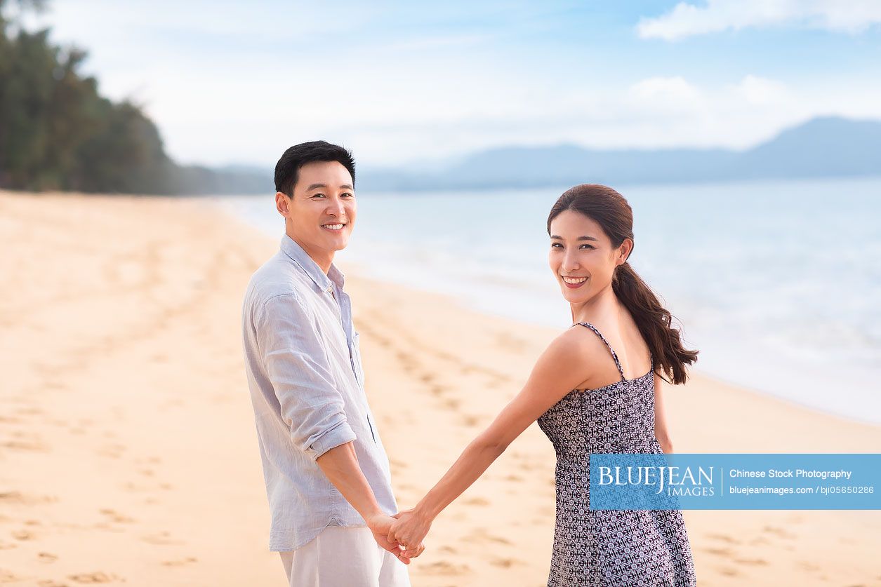 Happy young Chinese couple on beach