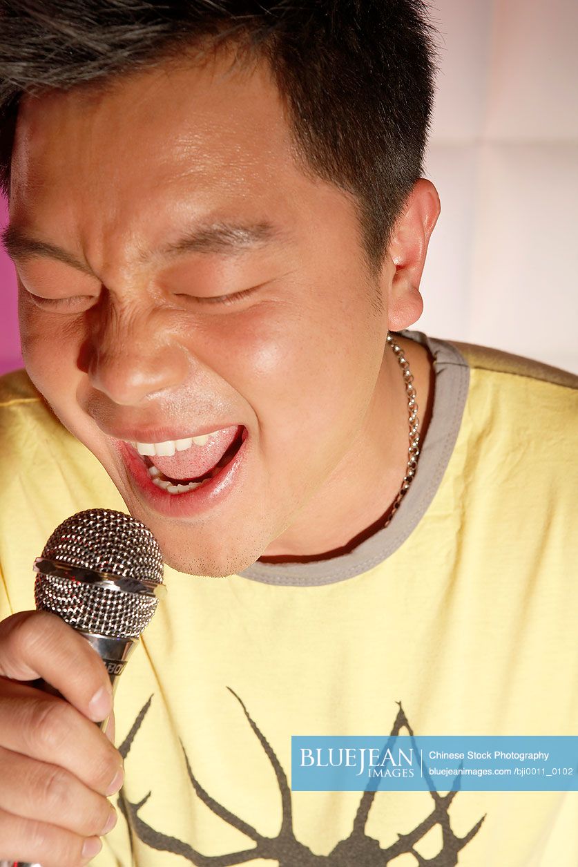 Young Chinese Man Passionately Singing Karaoke