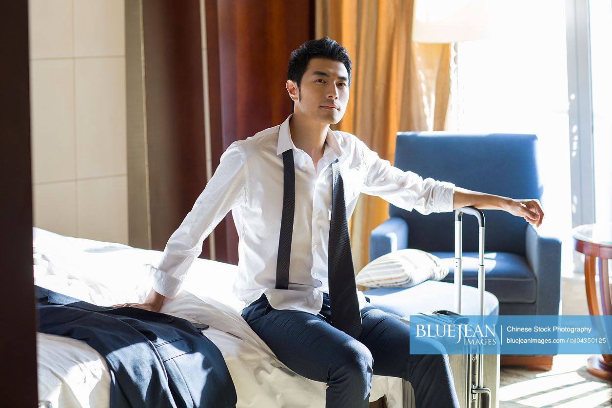 Young Chinese businessman resting in hotel room