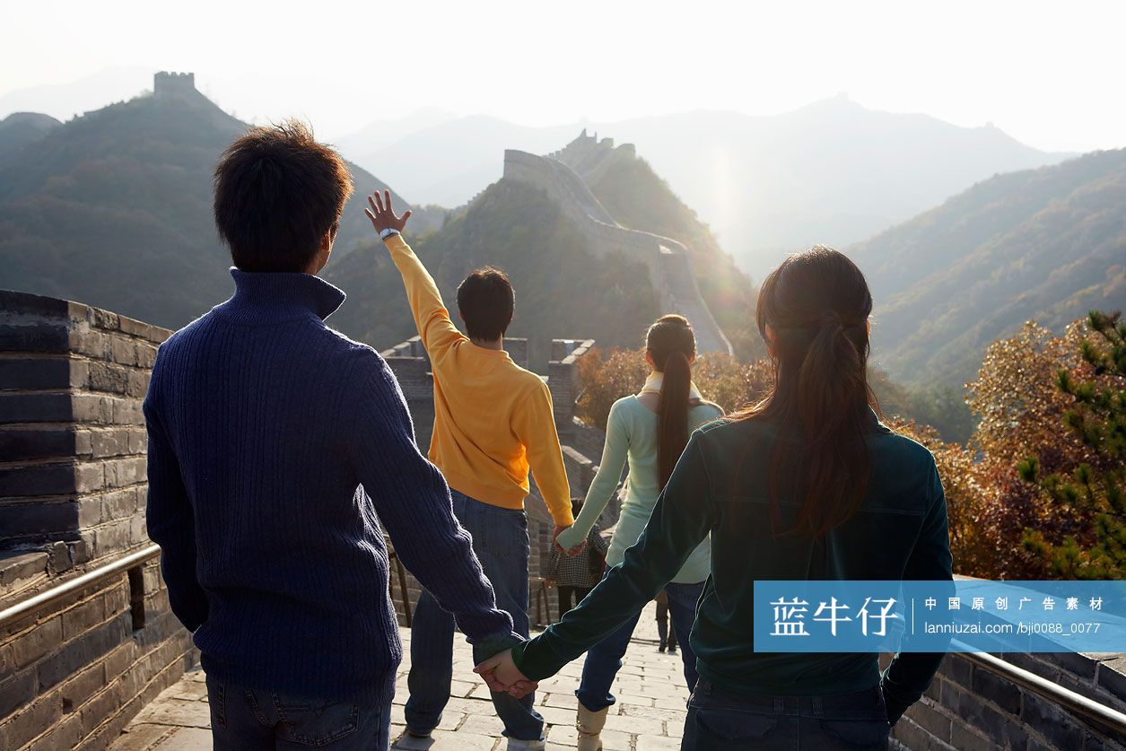 四个年轻人正在长城上远眺