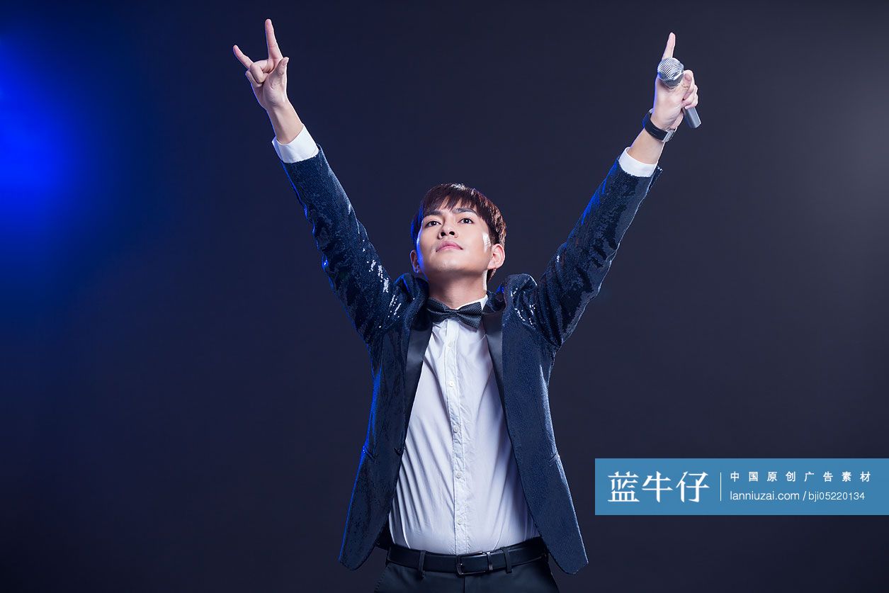 年轻男子拿着麦克风唱歌