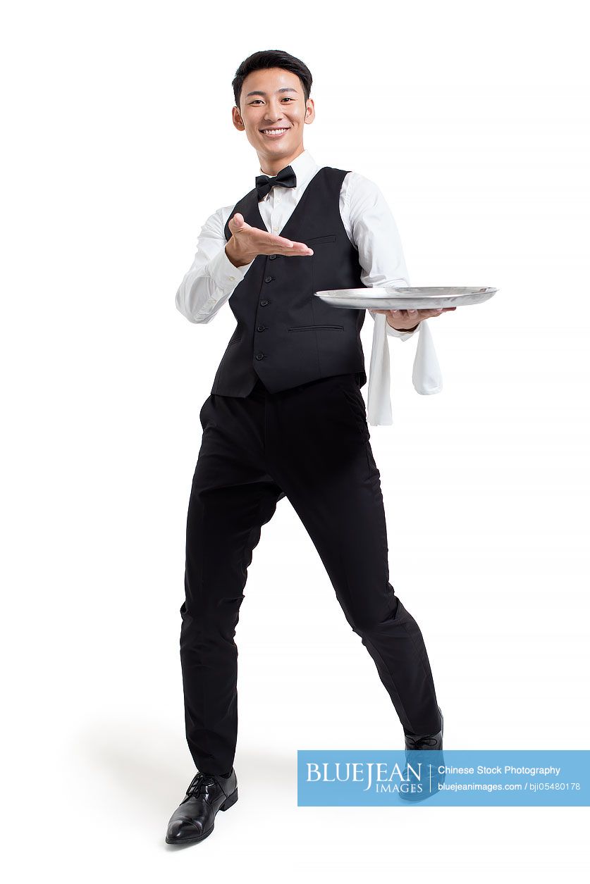 Cheerful young Chinese waiter serving food
