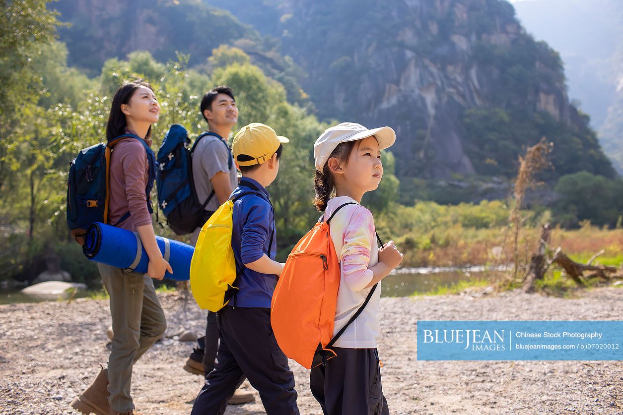 Happy young Chinese family hiking outdoors