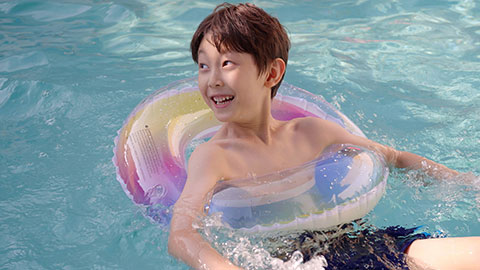 男孩在泳池里玩耍