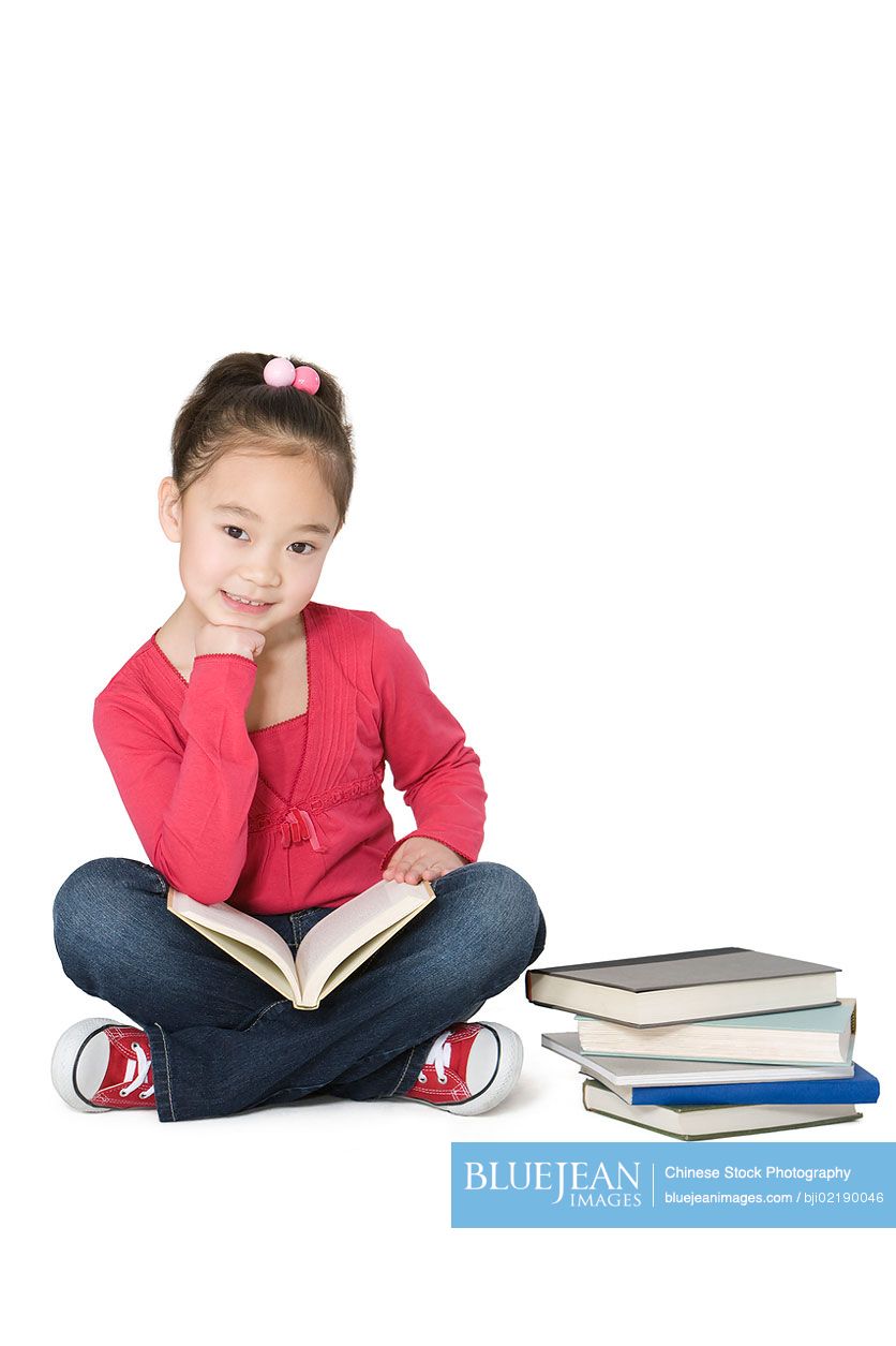 Young Chinese girl sitting and reading